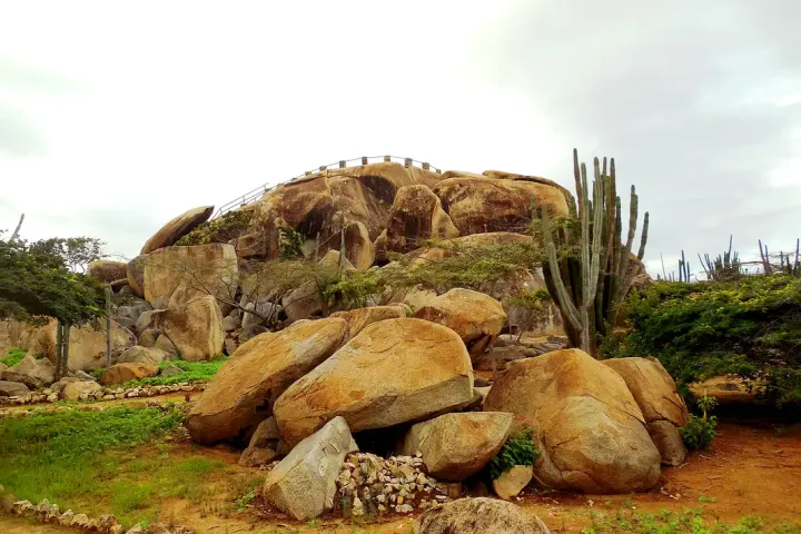Large boulders and cacti in a rocky landscape with overcast sky.